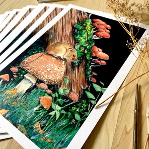 May include: A collection of watercolour art prints depicting a mouse on a mushroom, set in a forest with a tree trunk and other fungi. The artwork is detailed and realistic, with a palette of vibrant colours.