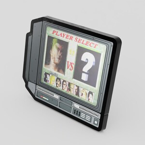 May include: A retro-style, rectangular sticker or magnet resembling an old television set. The screen displays "PLAYER SELECT" text, a character image, and a large question mark. Below are several character portraits. The frame is black and gray.