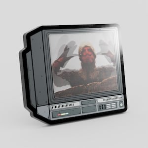 Op de afbeelding: Een grijze en zwarte retro televisie sticker met een persoon op het scherm. De persoon draagt een hoed en heft zijn handen op. De sticker heeft een witte achtergrond.