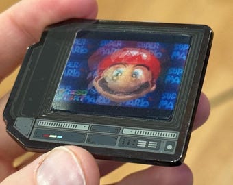 Pin's en émail CRTV lenticulaire de 6,35 cm (2,5 pouces) représentant un plombier à chapeau rouge.