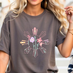 May include: A gray t-shirt with a floral design of a sun with eight rays. The sun is a stylized version of the Philippine sun, a symbol of the Philippines.