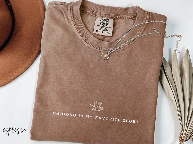 Show your love for the game with our “Mahjong Is My Favorite Sport” shirt! Perfect for Filipina moms, dads, and mahjong enthusiasts, this comfy Comfort Colors® tee is great for game nights or casual wear. A fun gift for players of American or traditional mahjong — stylish and spirited!