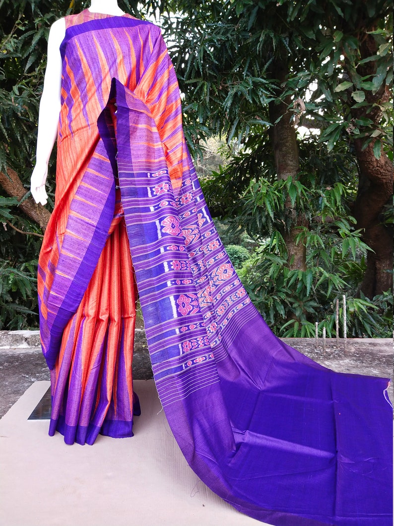 This saree comes with a blouse piece in royal blue. Handwoven orange and royal blue tussar ghicha saree with sambalpuri design in palla
