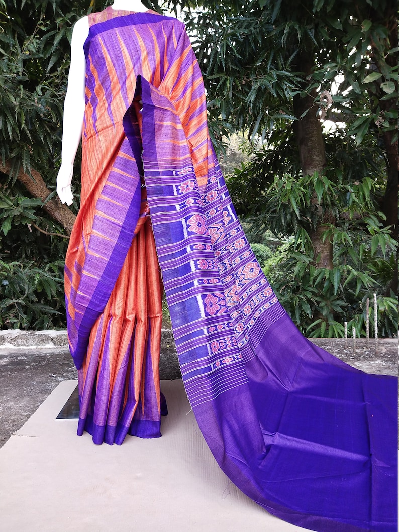 This saree comes with a blouse piece in royal blue. Handwoven orange and royal blue tussar ghicha saree with sambalpuri design in palla
