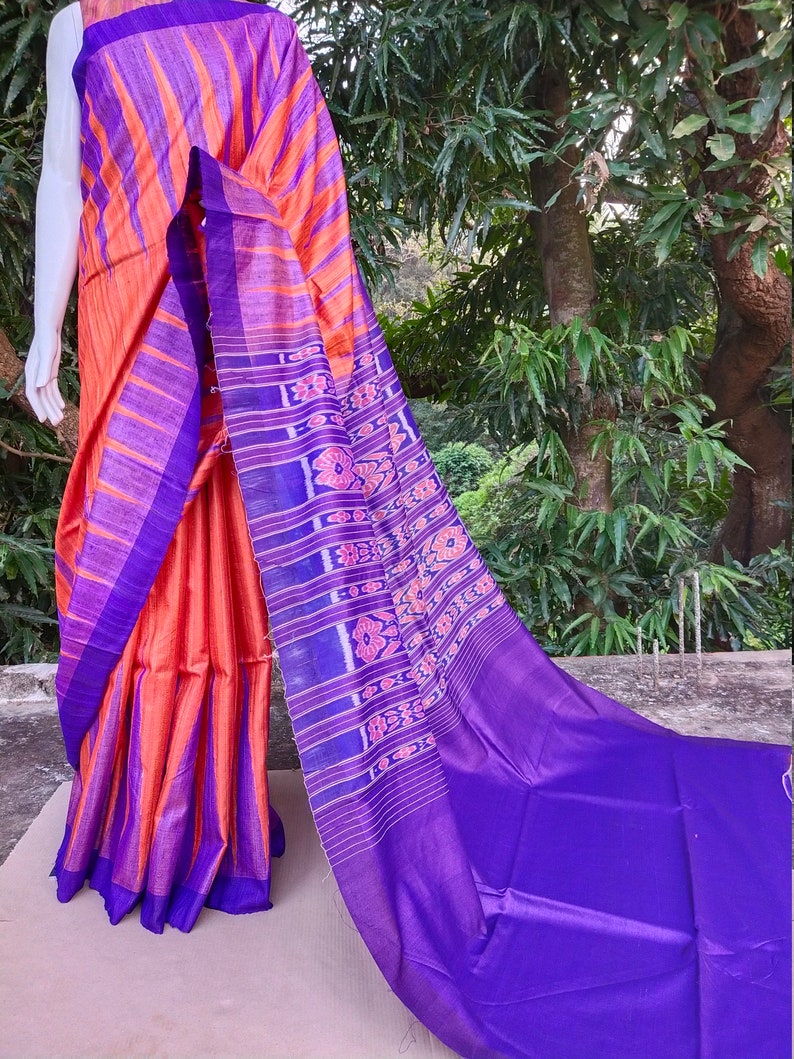 This saree comes with a blouse piece in royal blue. Handwoven orange and royal blue tussar ghicha saree with sambalpuri design in palla