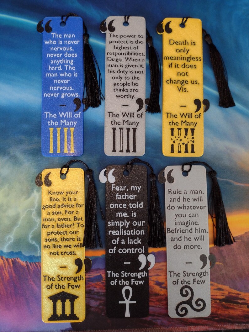 Peut inclure: Six marque-pages rectangulaires avec des citations et des d&eacute;tails de pompons noirs. Les marque-pages sont de diff&eacute;rentes couleurs, dont le bleu, le gris et le jaune. Chaque marque-page pr&eacute;sente une citation et un symbole.