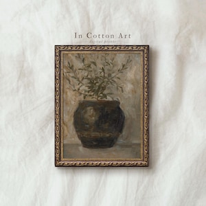 Op de afbeelding: Een ingelijste digitale print met een stilleven van een donkere vaas met groene bladeren. Het kunstwerk heeft een vintage esthetiek met een goudkleurige lijst. De tekst "In Cotton Art digital prints" is zichtbaar.