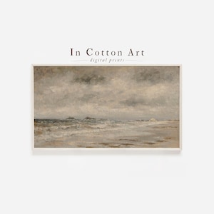 May include: A framed landscape print of a seascape with a cloudy sky. The artwork features muted tones of gray, beige, and brown, depicting waves, a beach, and distant land. The text "In Cotton Art - digital prints" is at the top.