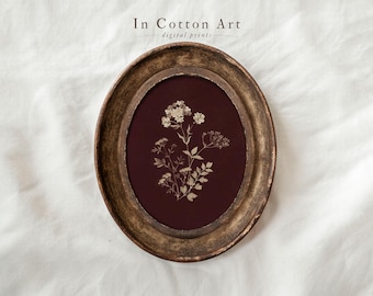 May include: An oval framed print featuring a botanical illustration of delicate white flowers and foliage against a deep burgundy background. The frame has a distressed gold finish, and the text "In Cotton Art digital prints" is at the top.