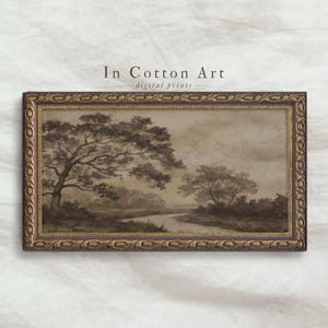 Puede incluir: Impresión artística de paisaje en tonos sepia en un marco dorado decorativo. La obra de arte representa una escena de río con árboles y un cielo nublado. El texto "In Cotton Art digital prints" está impreso en la parte superior de la imagen.