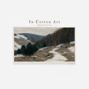 May include: A framed landscape print featuring a winter scene with snow-covered hills and a path winding through the trees. The artwork has a muted color palette with the text "In Cotton Art - digital prints" at the top.