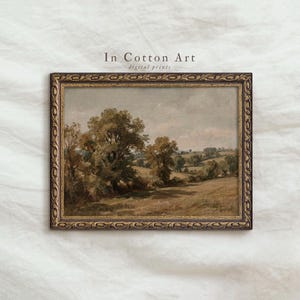 Puede incluir: Un cuadro de paisaje en un marco oscuro y ornamentado con árboles y colinas bajo un cielo nublado. El texto In Cotton Art digital prints es visible sobre el marco. La obra muestra tonos tierra apagados en marrón, verde y gris.