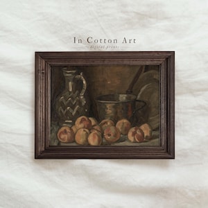 Puede incluir: Pintura enmarcada de naturaleza muerta con melocotones, una jarra decorativa y una olla de cobre. La obra de arte está en una paleta de colores oscuros y apagados con el texto "In Cotton Art" en la parte superior.