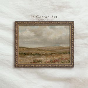 Peut inclure: Peinture de paysage de style ancien dans un cadre doré décoratif. L'œuvre représente un champ aux tons sourds de brun, vert et rose sous un ciel nuageux. Le texte "In Cotton Art digital prints" est visible.