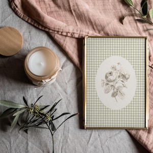 Pu&ograve; includere: Un'immagine incorniciata in oro con un motivo a quadri verdi e bianchi. L'immagine presenta un'illustrazione in bianco e nero di un bouquet di fiori su sfondo bianco.