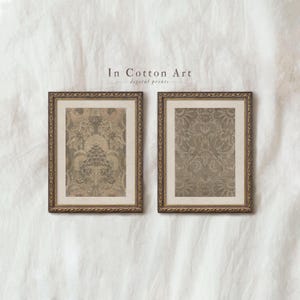 May include: Two framed vintage botanical prints with ornate gold frames. The prints feature detailed floral patterns in muted green and beige tones. The text "In Cotton Art digital prints" is visible above the frames.