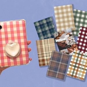 Pode incluir: Uma capa de telefone rosa e branca em vichy com um pop socket em forma de coração. A capa é cercada por oito quadrados com padrões diferentes, incluindo vichy, xadrez e tartã.