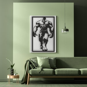 May include: A black and white silhouette of a muscular figure in a framed print. The figure is standing with arms outstretched, facing forward. The print is hanging on a light green wall above a green sofa.