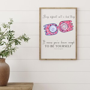 Puede incluir: Una impresi&oacute;n enmarcada con una ilustraci&oacute;n rosa y azul de un par de gafas con la cita "Ser diferente no es algo malo. Significa que eres lo suficientemente valiente para ser t&uacute; mismo." - Emma Livingston.