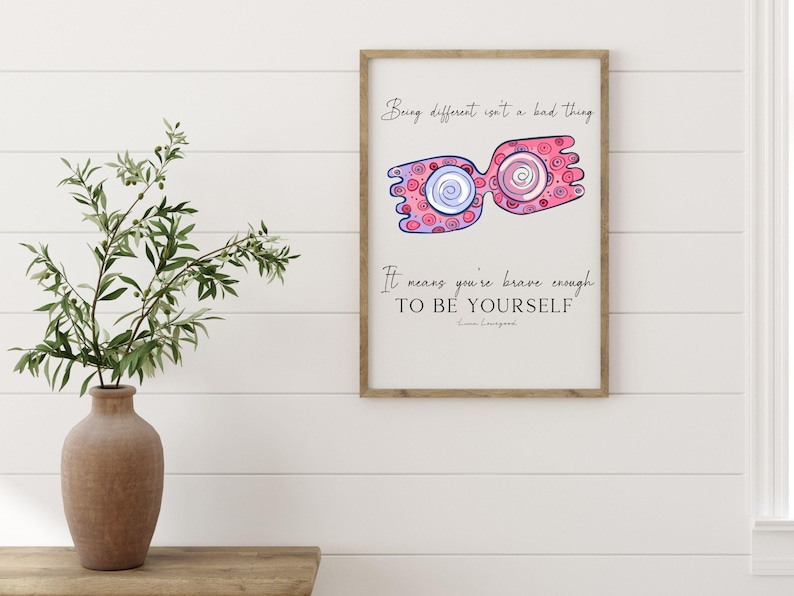 Puede incluir: Una impresi&oacute;n enmarcada con una ilustraci&oacute;n rosa y azul de un par de gafas con la cita "Ser diferente no es algo malo. Significa que eres lo suficientemente valiente para ser t&uacute; mismo." - Emma Livingston.