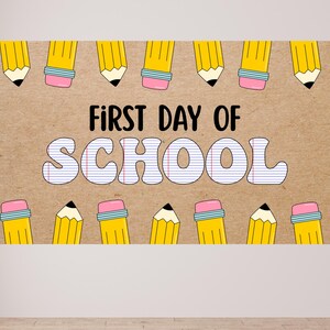 K&ouml;nnte beinhalten: Ein rechteckiges Schild mit dem Text "FIRST DAY OF SCHOOL" in Schwarz und Wei&szlig;. Das Wort "SCHOOL" ist im Stil von liniertem Papier gehalten. Gelbe Bleistifte mit rosa Radiergummis und schwarzen Spitzen umranden die Ober- und Unterseite des Schildes.
