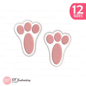 May include: Two pink paw print embroidery designs with white outlines. The design includes the text "12 SIZES" in a pink circle. The DF Embroidery design logo is in the bottom left corner.