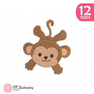 Könnte beinhalten: Ein braunes Affen-Stickdesign mit hellbraunem Gesicht, schwarzen Augen und einem lächelnden Mund. Das Design enthält den Text "12 GRÖSSEN" in einem rosa Kreis. Das Logo "DF Embroidery design" befindet sich unten links.