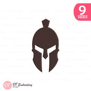 May include: A brown Spartan helmet design. The image features a detailed embroidered illustration of a classic Greek helmet, with a prominent visor and crest. The design is set against a white background, with the text "9 SIZES" in a pink oval.