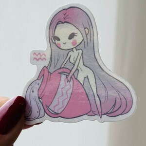 K&ouml;nnte beinhalten: Ein rosa und lilafarbener Aufkleber mit einer Cartoon-Illustration einer Frau, die Wasser aus einem rosa Krug gie&szlig;t. Die Frau hat langes lila Haar und tr&auml;gt ein rosa Kleid. Der Aufkleber tr&auml;gt das astrologische Symbol f&uuml;r Wassermann.
