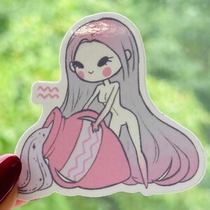 K&ouml;nnte beinhalten: Ein rosa und wei&szlig;er Aufkleber mit einer Cartoon-Illustration einer Frau, die Wasser aus einem rosa Krug gie&szlig;t. Die Frau hat langes, violettes Haar und tr&auml;gt ein rosa Kleid. Der Aufkleber tr&auml;gt das astrologische Symbol f&uuml;r Wassermann.