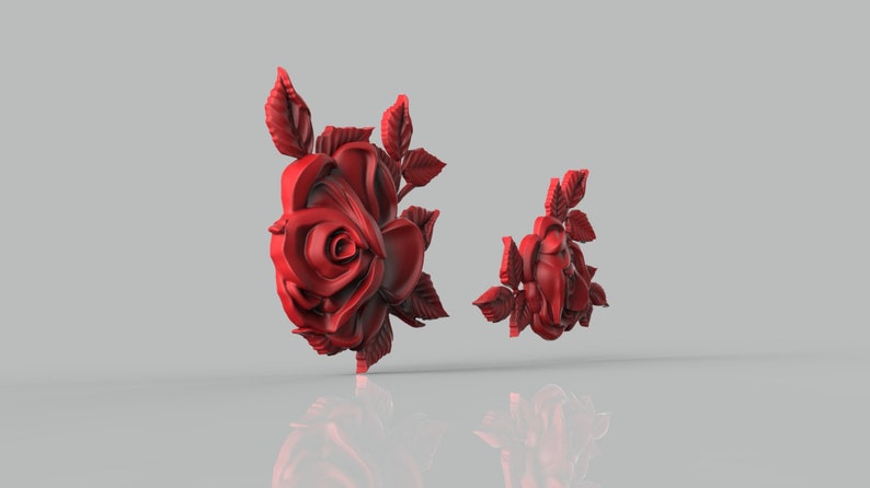 May include: Two red 3D printed rose sculptures. The larger rose is in full bloom with leaves, while the smaller rose is partially open with leaves.
