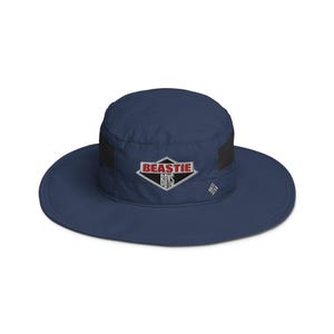 May include: A navy blue bucket hat with a black mesh panel and a diamond-shaped patch that says "BEASTIE BOYS" in red and white letters.