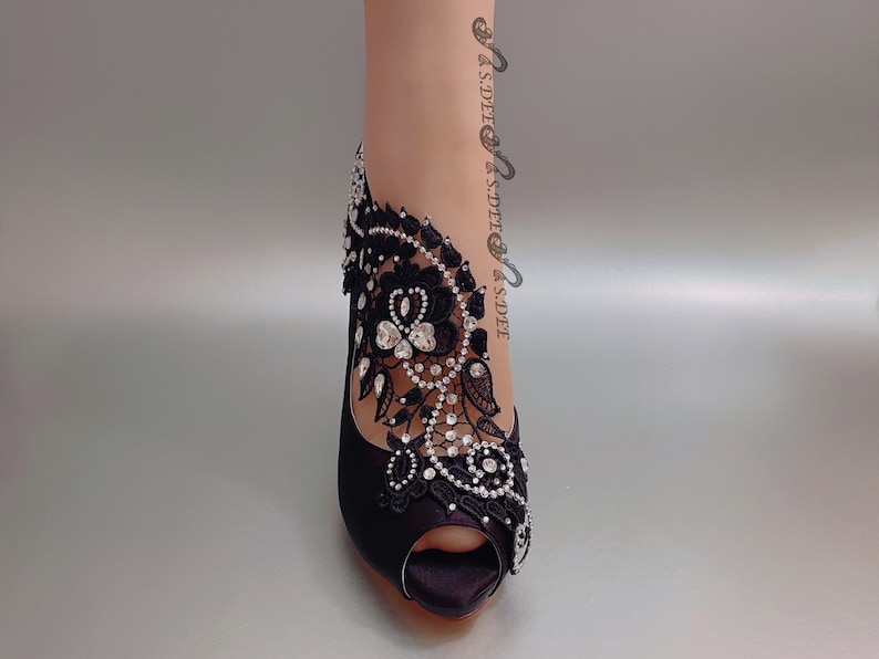 Peut inclure: Chaussures &agrave; talons noirs en satin avec une embellissement en dentelle noire et strass.