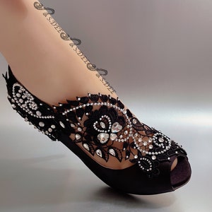 Peut inclure: Chaussures &agrave; talons noirs en satin avec une d&eacute;licate superposition de dentelle noire et des embellissements scintillants en strass.