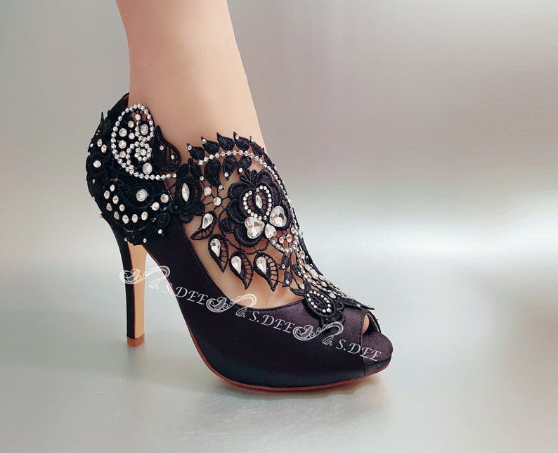 Peut inclure: Chaussures &agrave; talons aiguilles en satin noir avec une d&eacute;licate dentelle noire et des strass sur la bride de cheville.
