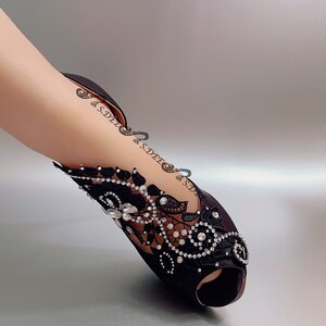 Peut inclure: Chaussures &agrave; talons noirs en satin avec une embellissement en dentelle noire et strass.