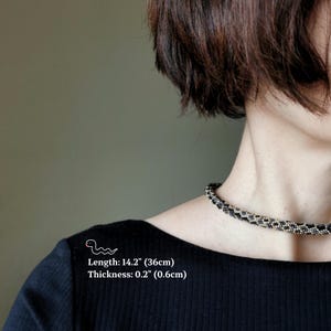 Op de afbeelding: Een zwarte en witte kralen choker ketting met een lengte van 36 cm (14,2 inch) en een dikte van 0,6 cm (0,2 inch).