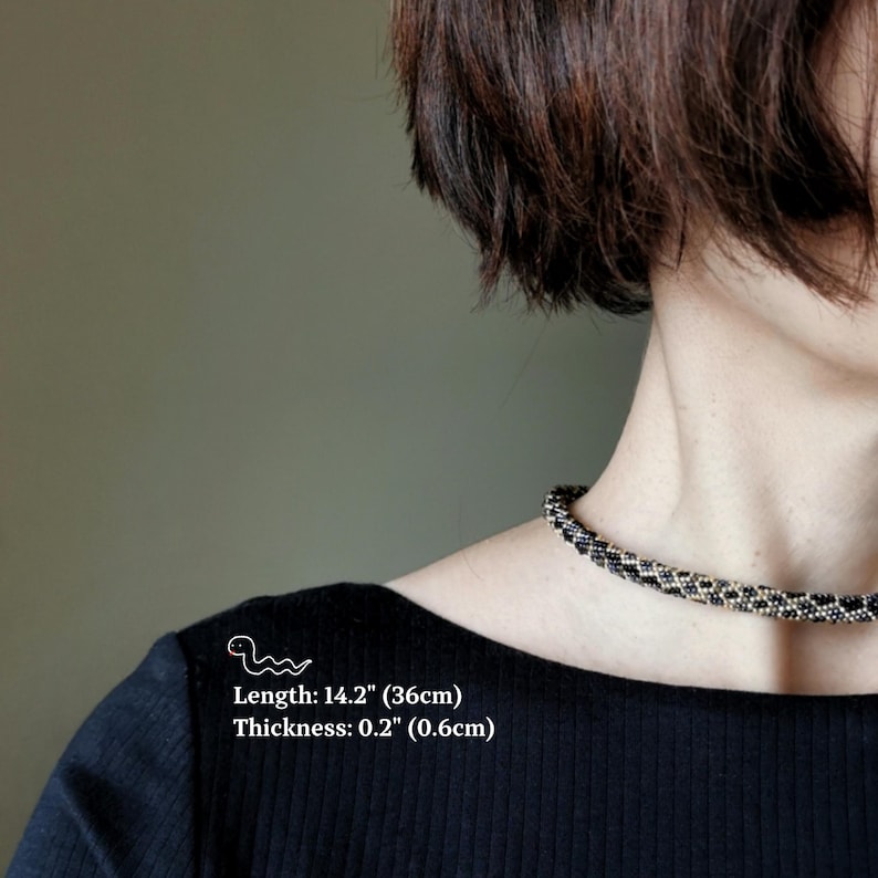 Op de afbeelding: Een zwarte en witte kralen choker ketting met een lengte van 36 cm (14,2 inch) en een dikte van 0,6 cm (0,2 inch).