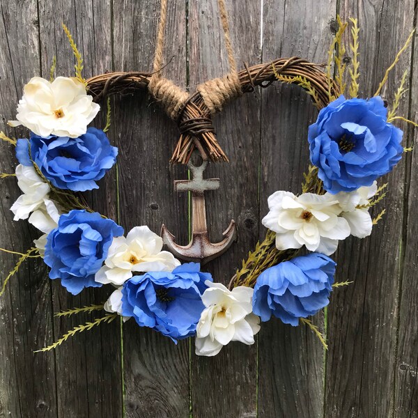 Nautical Farmhouse heart shaped grapevine wreath with anchor pendant. Faux flowers of ocean blue peonies and cream Delphinium.