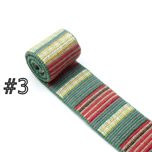 May include: A green, red, white, and brown striped woven ribbon. The ribbon is rolled up and the label #3 is visible.