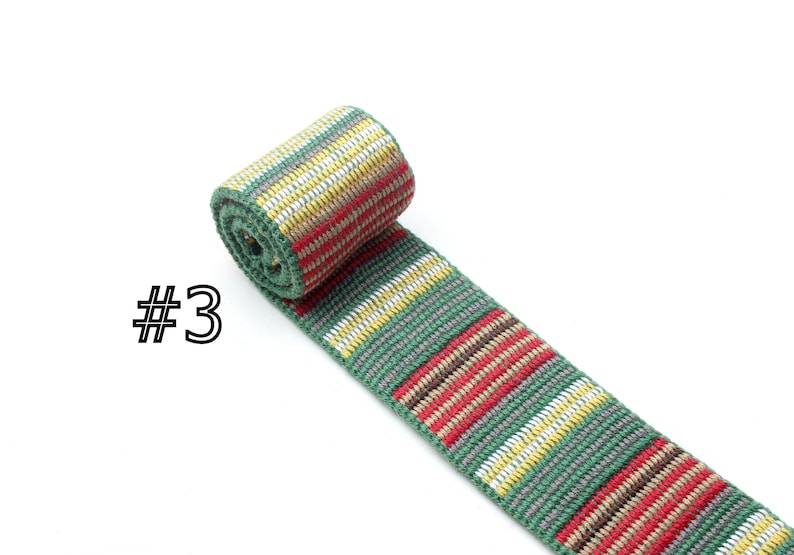 May include: A green, red, white, and brown striped woven ribbon. The ribbon is rolled up and the label #3 is visible.