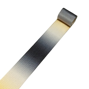 May include: A roll of ombre webbing ribbon in shades of beige, grey, and black.