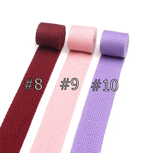 May include: Three rolls of cotton webbing in burgundy, pink, and lavender. The rolls are labeled #8, #9, and #10.