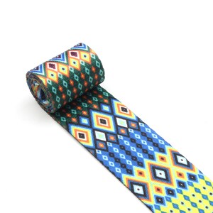 May include: A green, blue, yellow, and orange patterned webbing with a geometric diamond design.