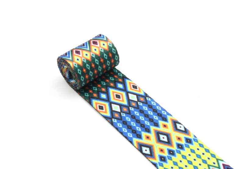 May include: A green, blue, yellow, and orange patterned webbing with a geometric diamond design.