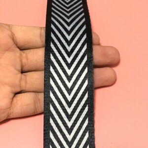 K&ouml;nnte beinhalten: Schwarz-wei&szlig;es Chevron-Musterband. Das Band ist etwa 2,5 cm breit.