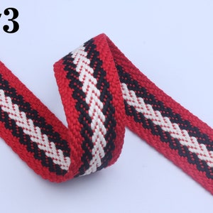 May include: Red, black, and white woven cotton webbing with a chevron pattern. #3