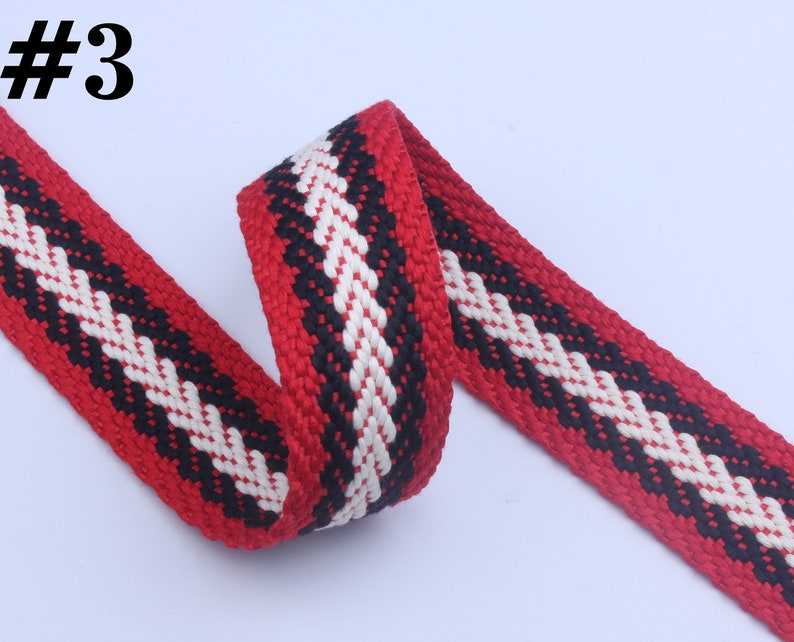 May include: Red, black, and white woven cotton webbing with a chevron pattern. #3