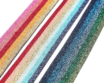 Pode incluir: Quatro bandas elásticas listradas diferentes com um brilho metálico. As bandas são de várias cores, incluindo vermelho, laranja, rosa, azul, verde e dourado.