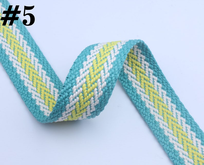 May include: A turquoise, white, and yellow woven ribbon with a chevron pattern. #5